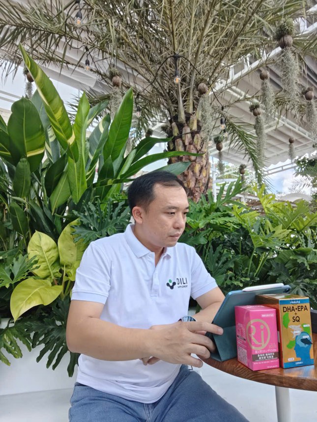 ThS. Phan Hồng Sơn ngồi cùng hai hộp Rich Coenzyme Q10 và DHA·EPA + SQ